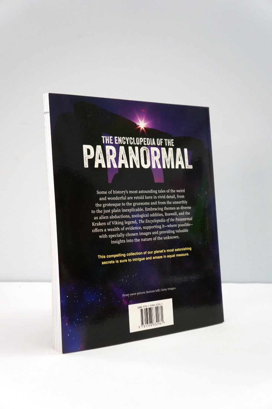 Book titled 'The Encyclopedia of the Paranormal' on a white background