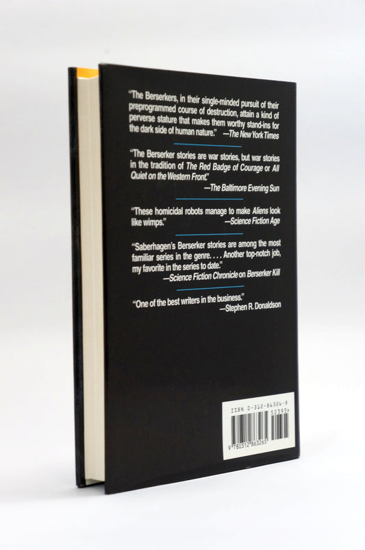 The back cover of a black hardcover book standing upright on a white background, featuring white review quotes, a barcode, and a small yellow accent on the left edge.