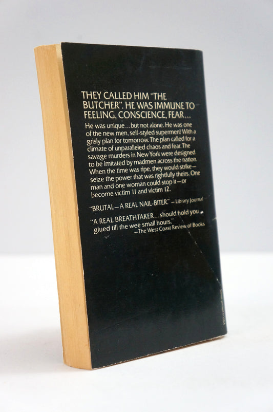 A hardcover book standing upright at a slight angle, showing a black front cover with white text and a light wood-toned spine or side edge, photographed against a plain light background.