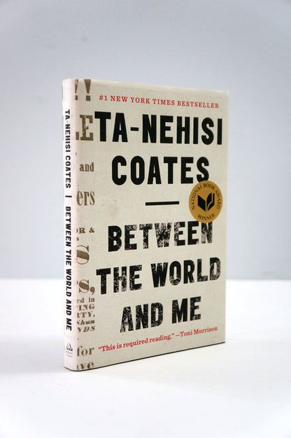 Book titled 'Between the World and Me' by Ta-Nehisi Coates on a gray background