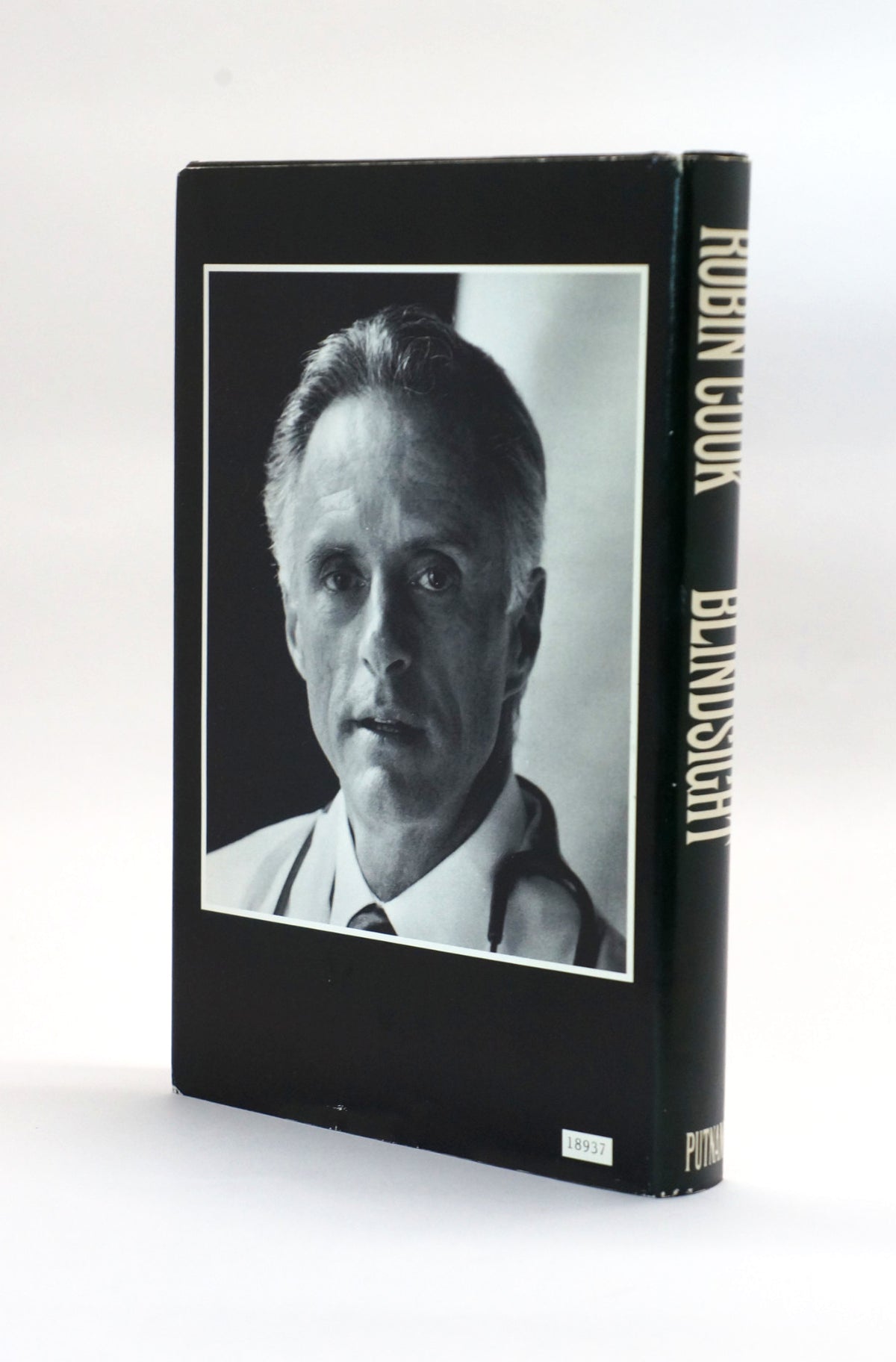 A hardcover book titled 'Blindsight' by Robin Cook, featuring a black cover with a black-and-white portrait photograph and gold lettering on the spine, photographed against a plain white background.