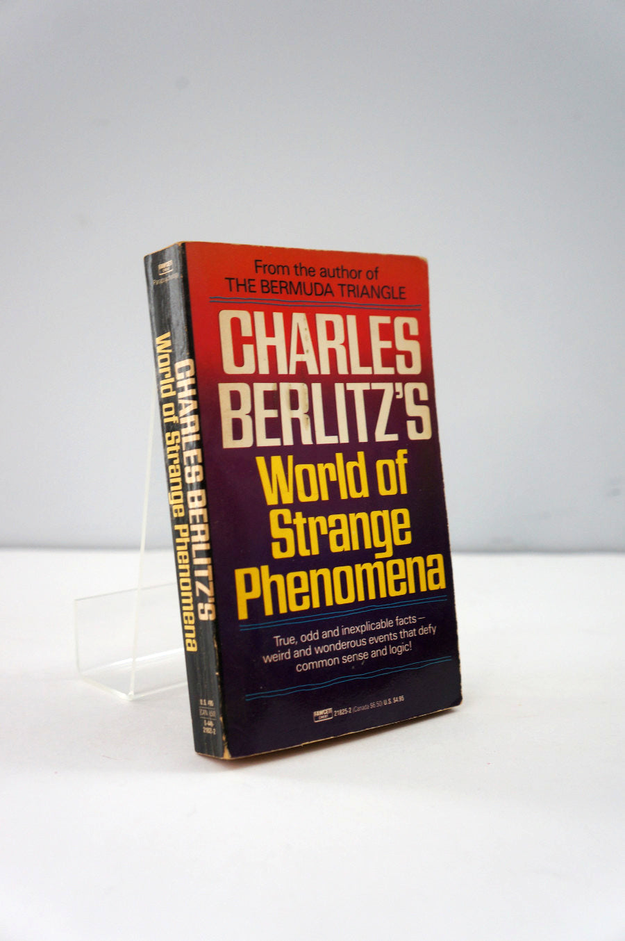 Book titled 'World of Strange Phenomena' by Charles Berlitz on a white background