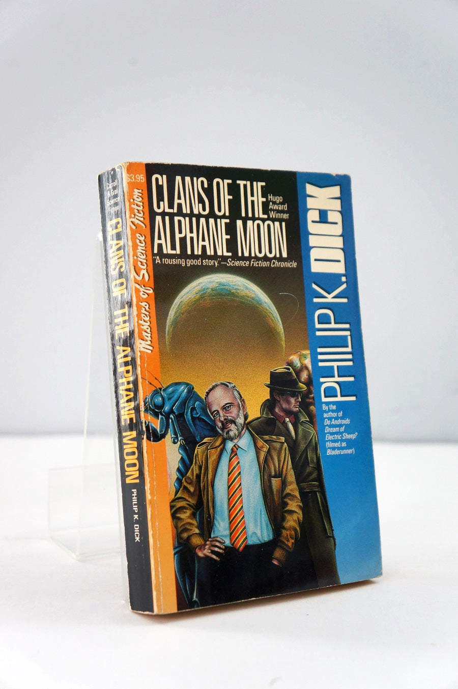 Book titled 'Clans of the Alphanе Moon' by Philip K. Dick on a white background