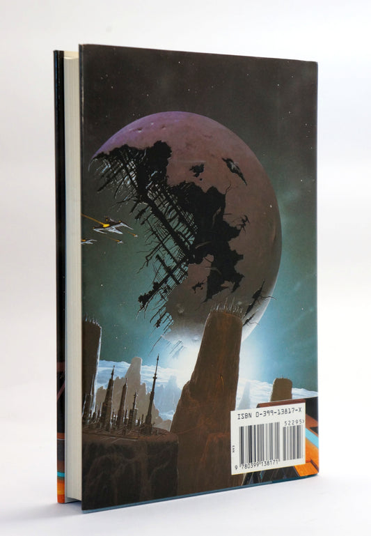 A hardcover book standing upright, showing the back cover with a sci-fi illustration of a large planet or moon over a futuristic city, photographed against a plain light background.
