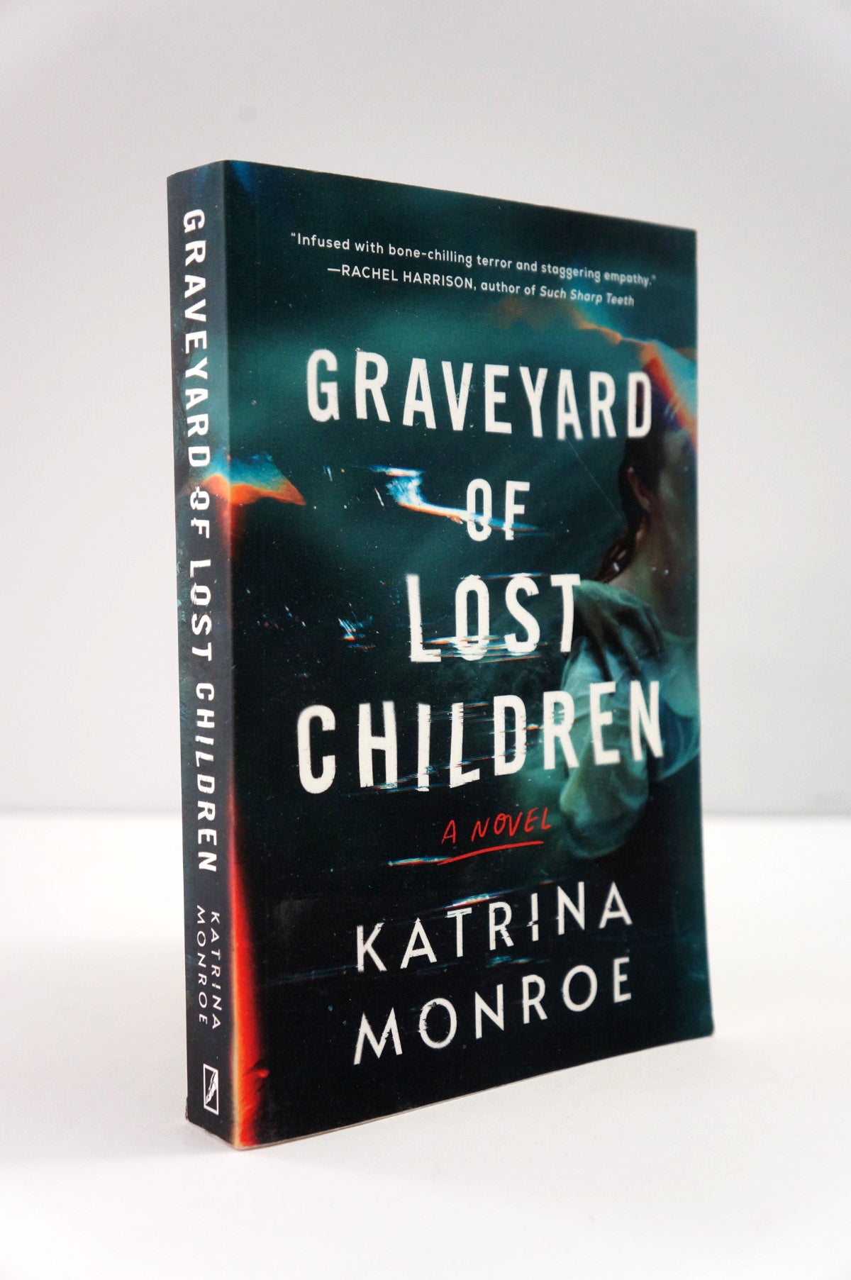 Book titled 'Graveyard of Lost Children' by Katrina Monroe on a white background