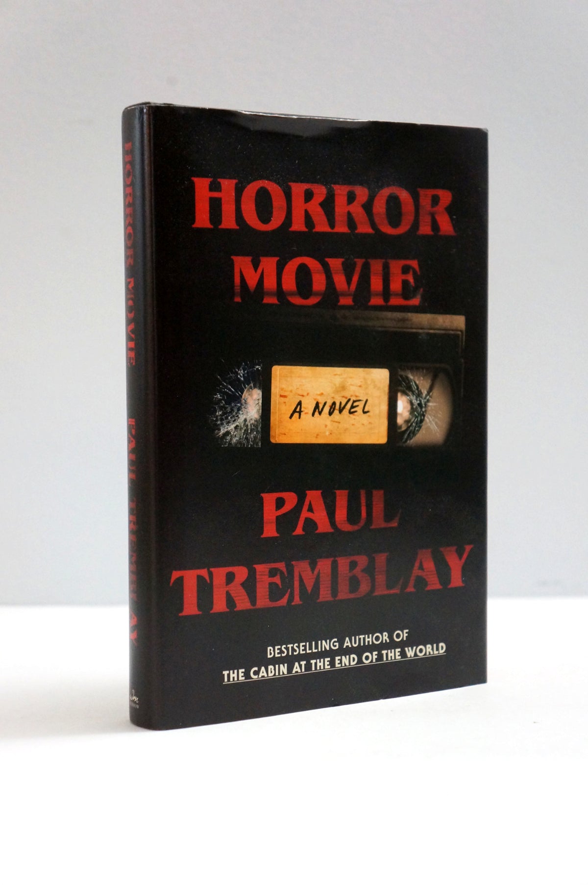A hardcover book titled 'Horror Movie' by Paul Tremblay, featuring a black cover with bold red title text and a central cassette tape graphic with a beige label reading 'A Novel'.
