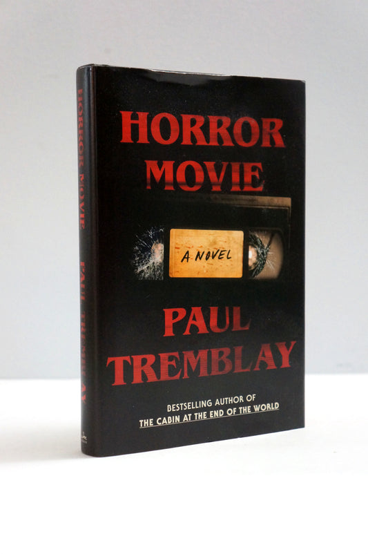 A hardcover book titled 'Horror Movie' by Paul Tremblay, featuring a black cover with bold red title text and a central cassette tape graphic with a beige label reading 'A Novel'.