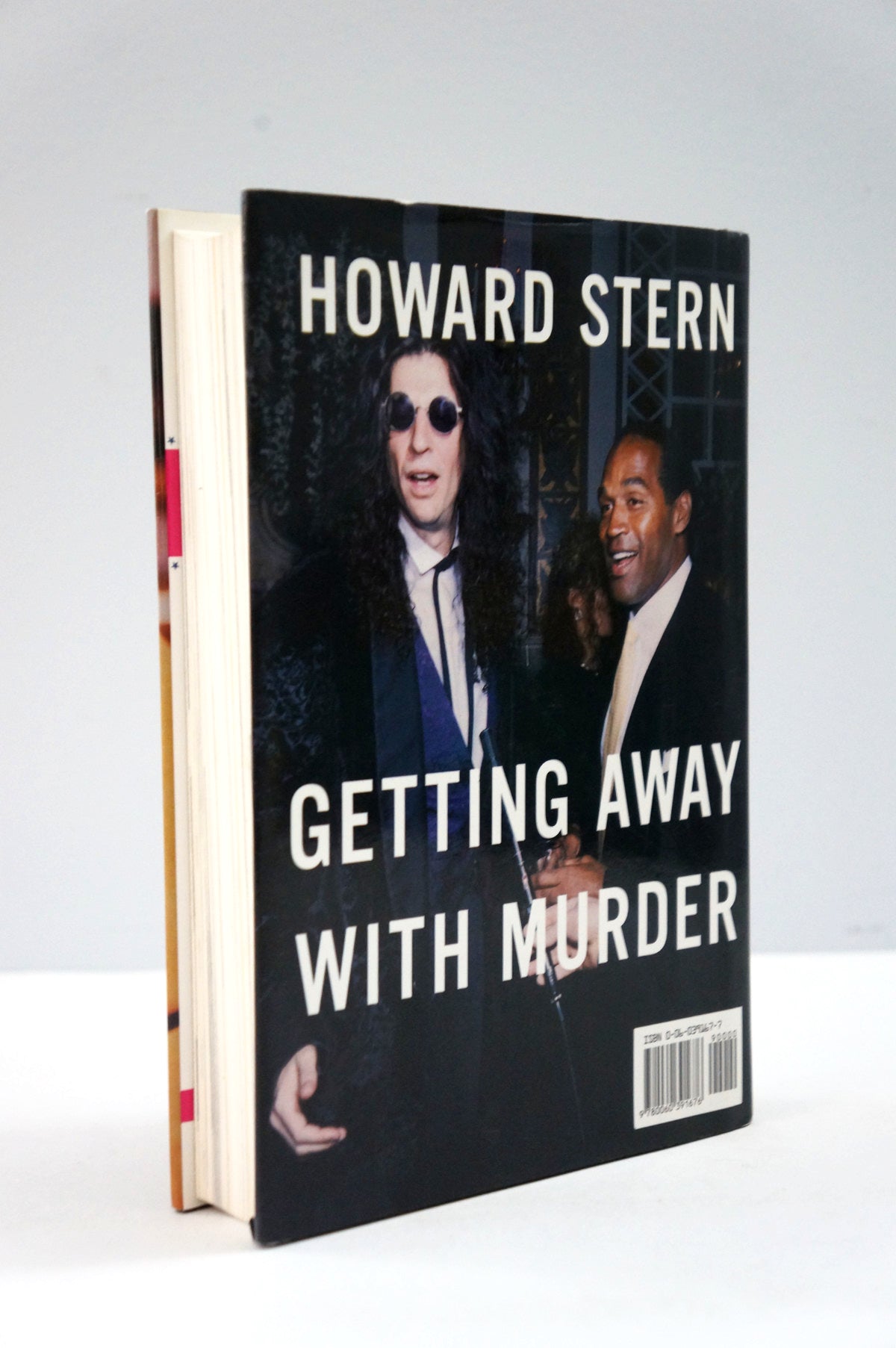 A hardcover book titled 'Getting Away with Murder' by Howard Stern, standing upright against a light gray background. The cover features a black background with a color photograph of Howard Stern in sunglasses and another man, with bold white text.