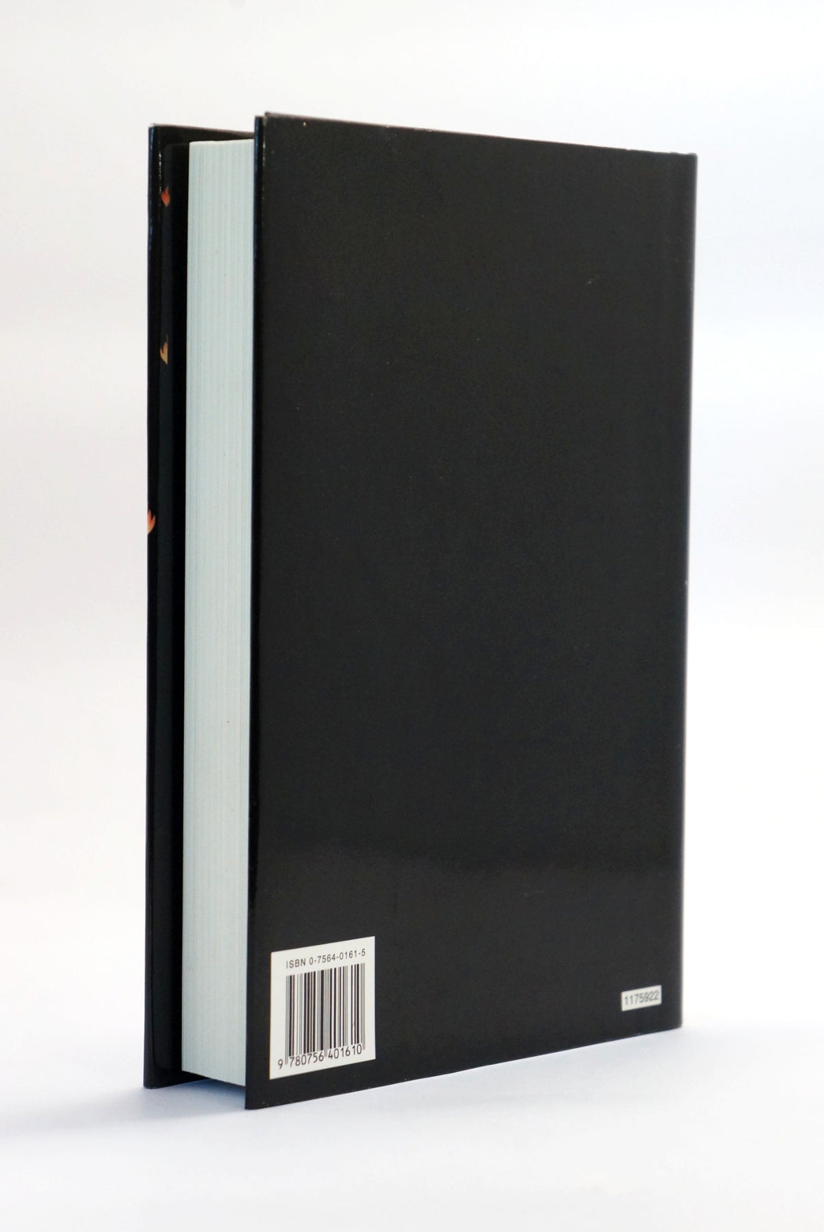 The back cover of a hardcover book, shown standing upright at a slight angle. The cover is solid black with a white barcode label near the bottom left and a small white publisher logo on the bottom right.
