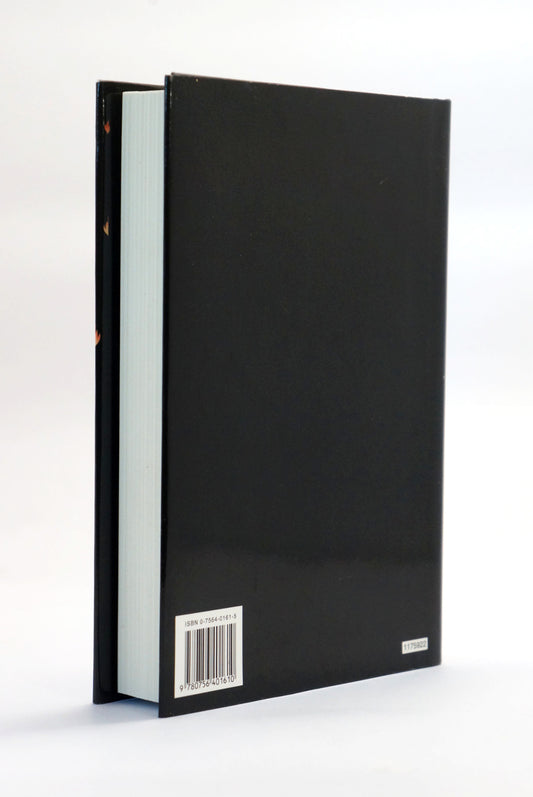 The back cover of a hardcover book, shown standing upright at a slight angle. The cover is solid black with a white barcode label near the bottom left and a small white publisher logo on the bottom right.