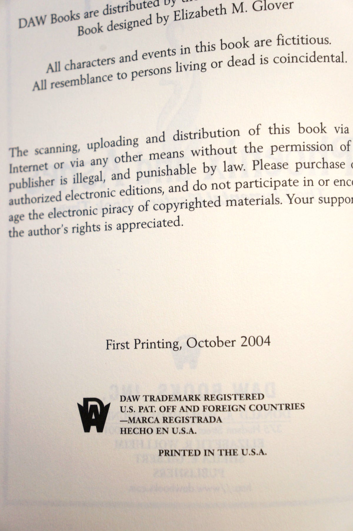 A photographed page from a book or booklet showing printed text about fictional characters, publisher distribution, copyright, and a DAW trademark mark, with a light gray background and faint watermarking.