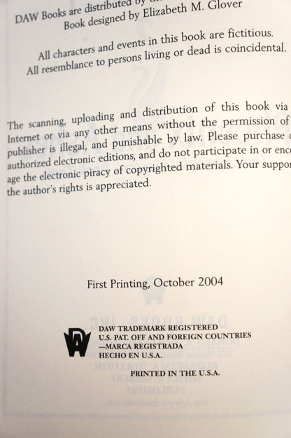 A photographed page from a book or booklet showing printed text about fictional characters, publisher distribution, copyright, and a DAW trademark mark, with a light gray background and faint watermarking.