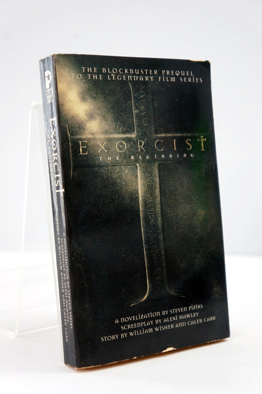 Book titled 'Exorcist: The Beginning' with a cross design on the cover.