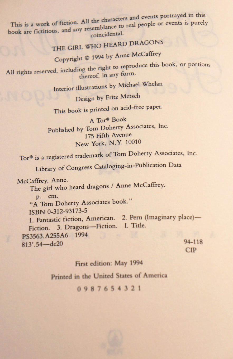 A photographed book interior page showing printed copyright and publication information for 'The Girl Who Heard Dragons' by Anne McCaffrey, including publisher text, ISBN, and printing details on an off-white page.