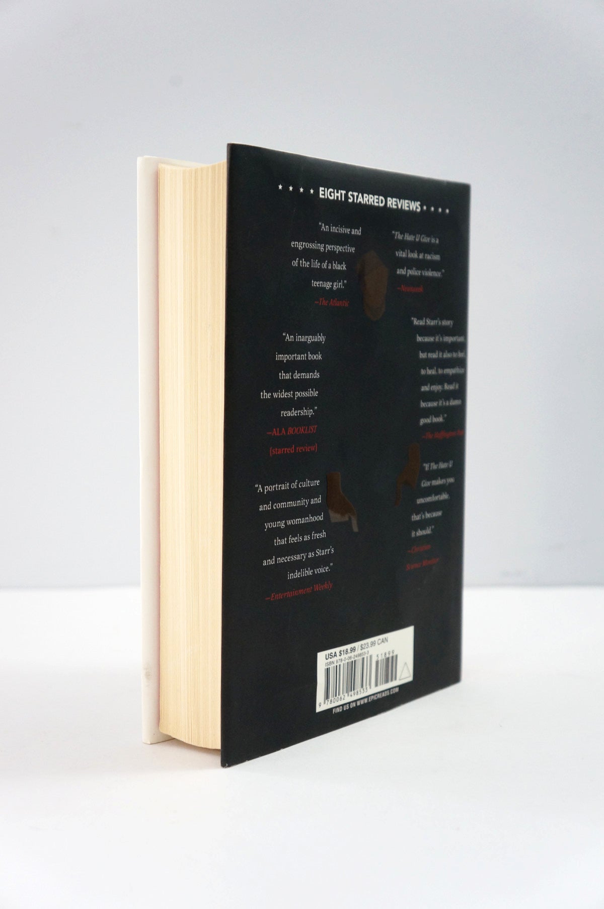 Book with a black cover and beige pages on a white background