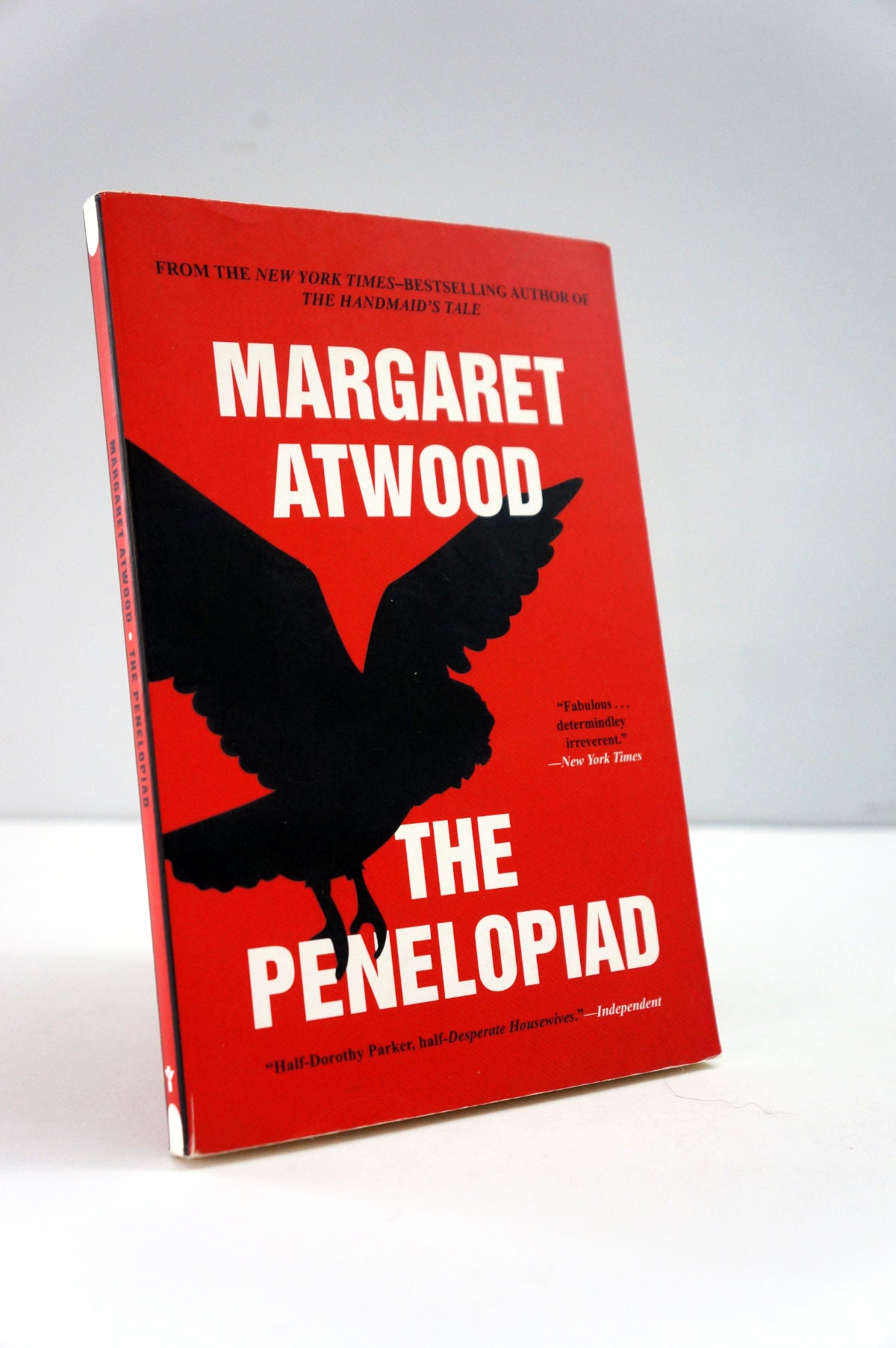 Book titled 'The Penelopiad' by Margaret Atwood with a red cover and black silhouette of a bird.