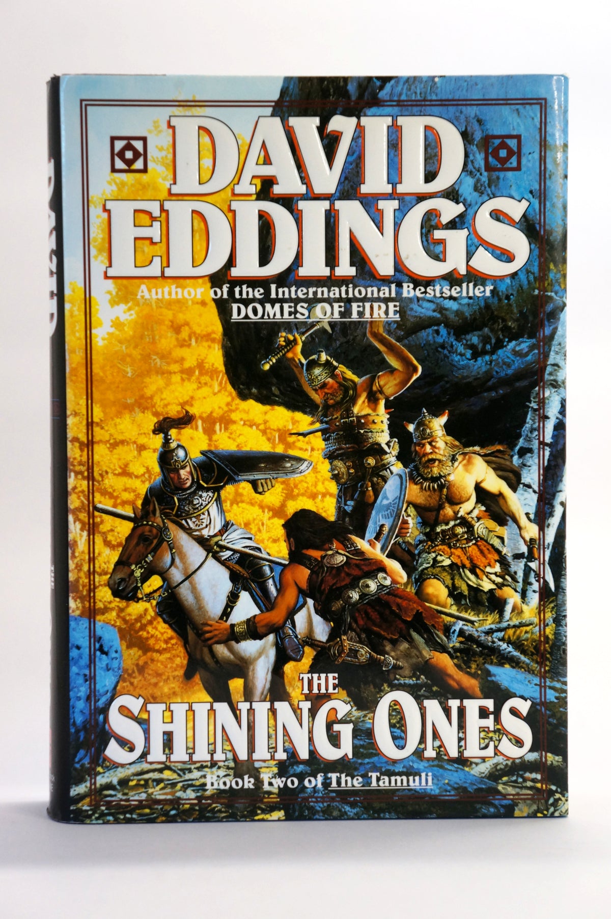 A vintage hardcover book of David Eddings' 'The Shining Ones' (Book Two of The Tamul) standing upright against a plain white background.