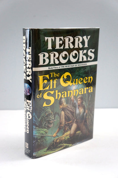 A hardcover book of Terry Brooks' 'The Elf Queen of Shannara' standing upright on a white surface against a light gray background.